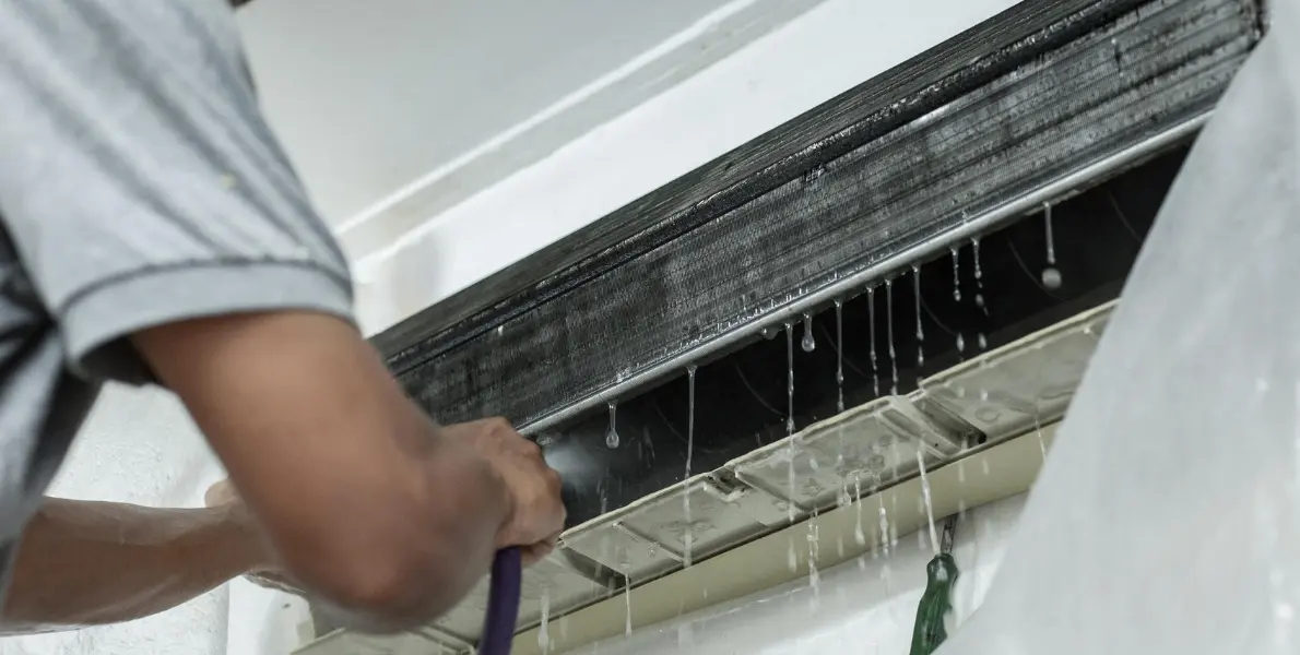 AC coil and filter being cleaned by technician